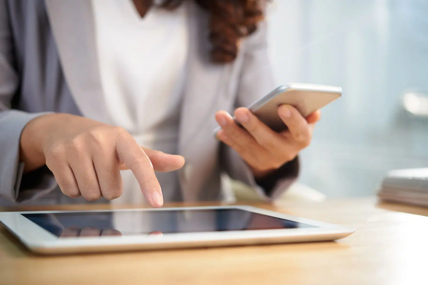 Mujer usando tablet y smartphone a la vez.